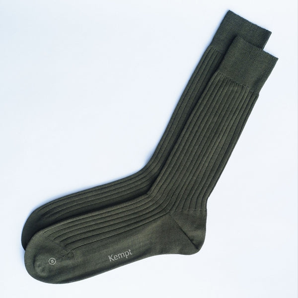 Pair of green socks with 'Kempt' branding on a white background