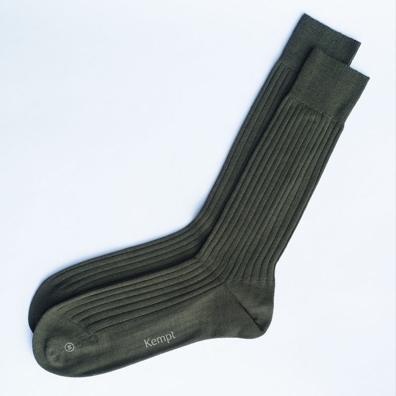 Pair of green socks with 'Kempt' branding on a white background